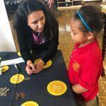 HFS staff member helps a student coint her coins