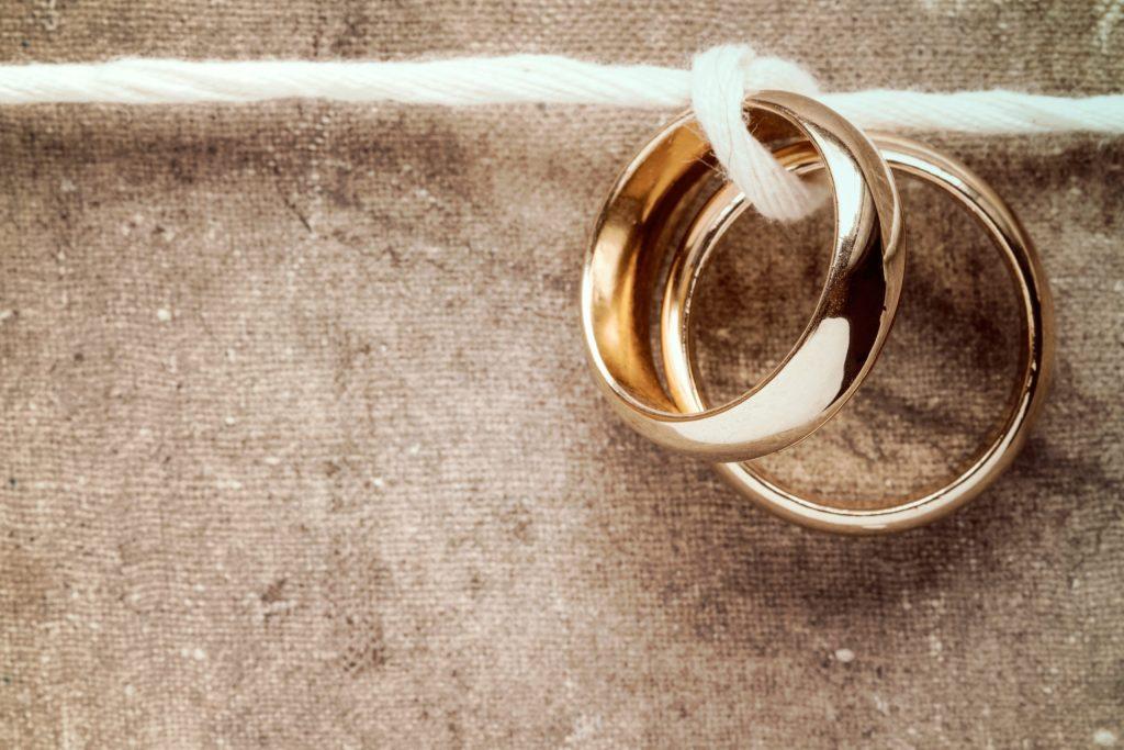 two gold rings hanging on a white string
